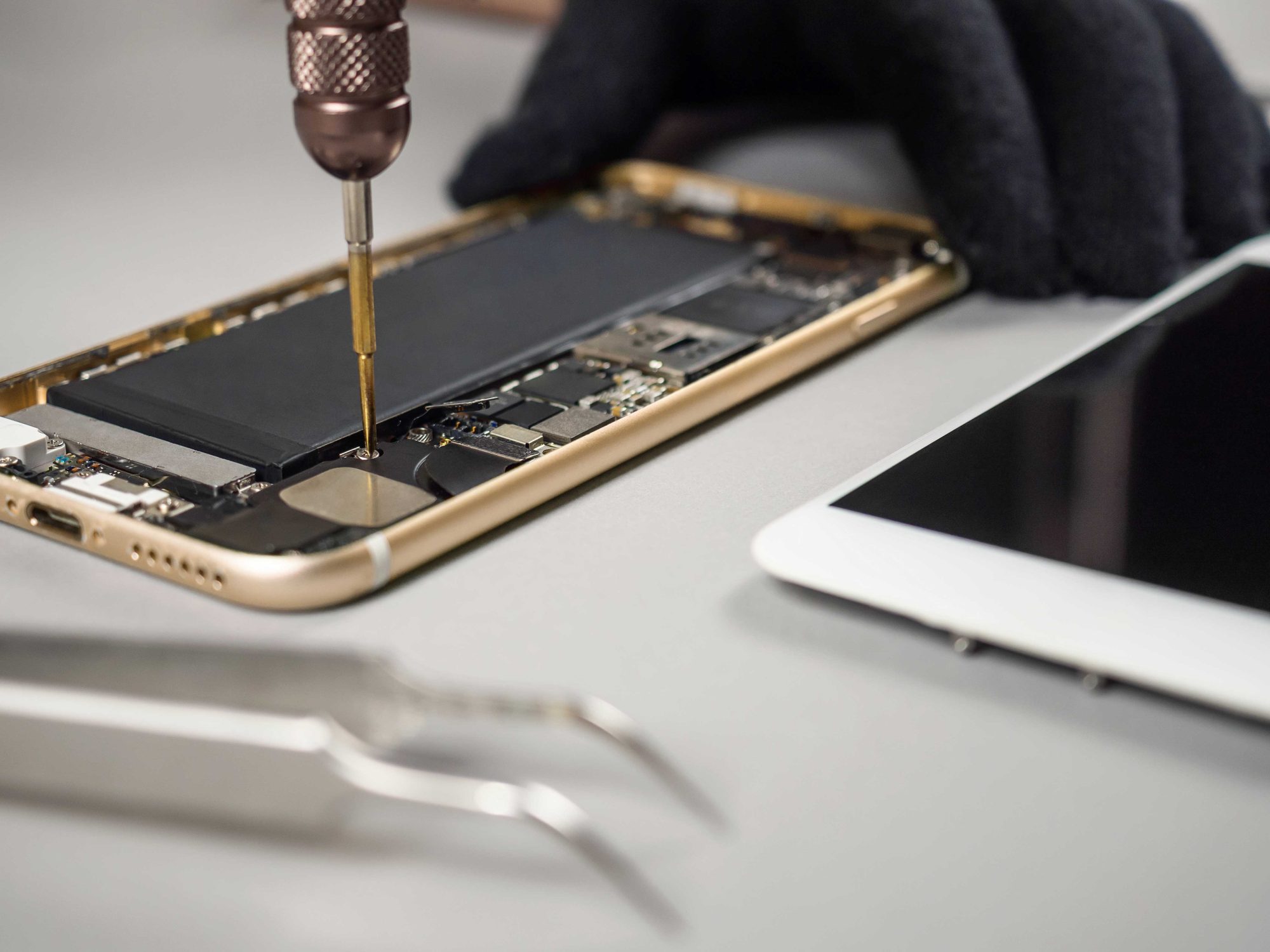 Technician repairing broken smartphone on desk. Technician or engineer disassembling components broken smartphone for repair or replace new part on desk